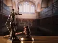 Temida z wagą i mieczem, obok młotka sędziowskiego. Symbol sprawiedliwości, rozstrzygania sporów, w tym służebności mieszkania.