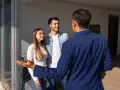Młoda para, potencjalni najemcy, słucha prezentacji mieszkania od wynajmującego.