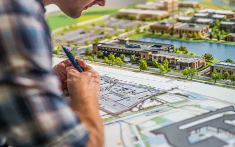 Architekt analizuje model urbanistyczny, planując rozwój terenu. To właśnie mpzp co to za dokument, który określa przeznaczenie działek.