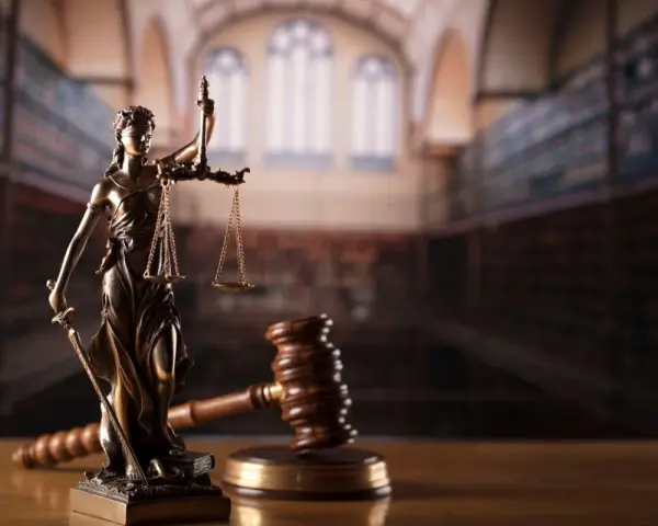 Temida z wagą i mieczem, obok młotka sędziowskiego. Symbol sprawiedliwości, rozstrzygania sporów, w tym służebności mieszkania.
