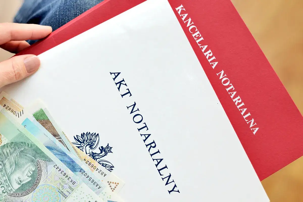 Akt notarialny i polskie banknoty. Dokument z kancelarii notarialnej, który może być podstawą do zawarcia umowy deweloperskiej.